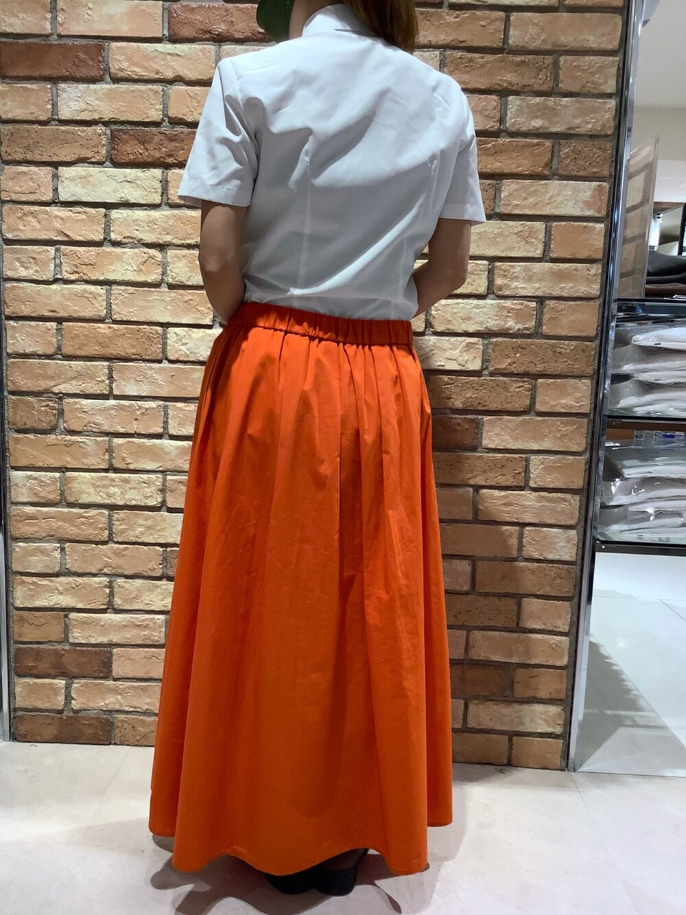 ホワイト系のビジネスシャツを着用したレディースの夏コーディネートの3枚目の写真