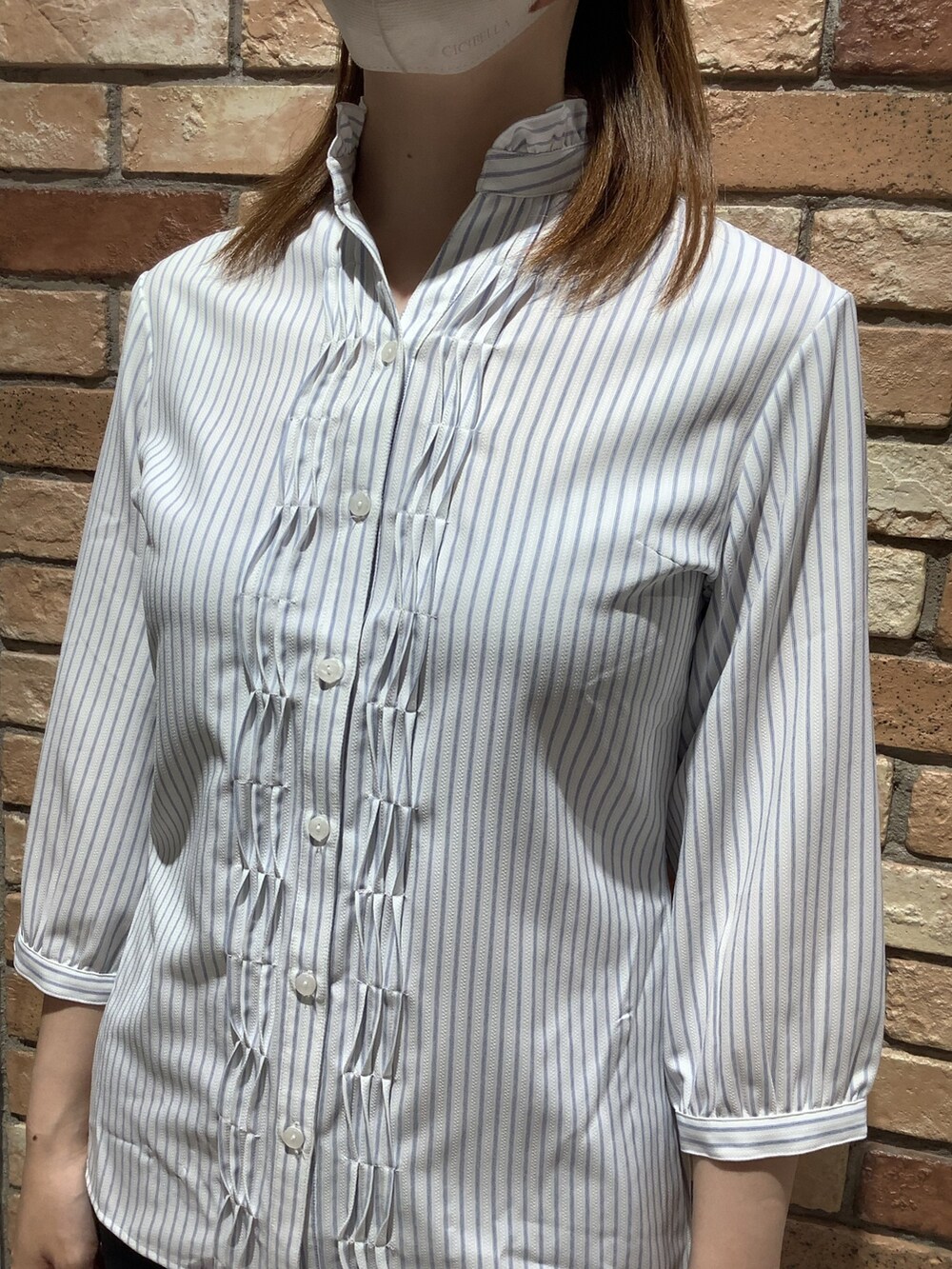 ブルー系のビジネスシャツを着用したレディースの春コーディネートの2枚目の写真