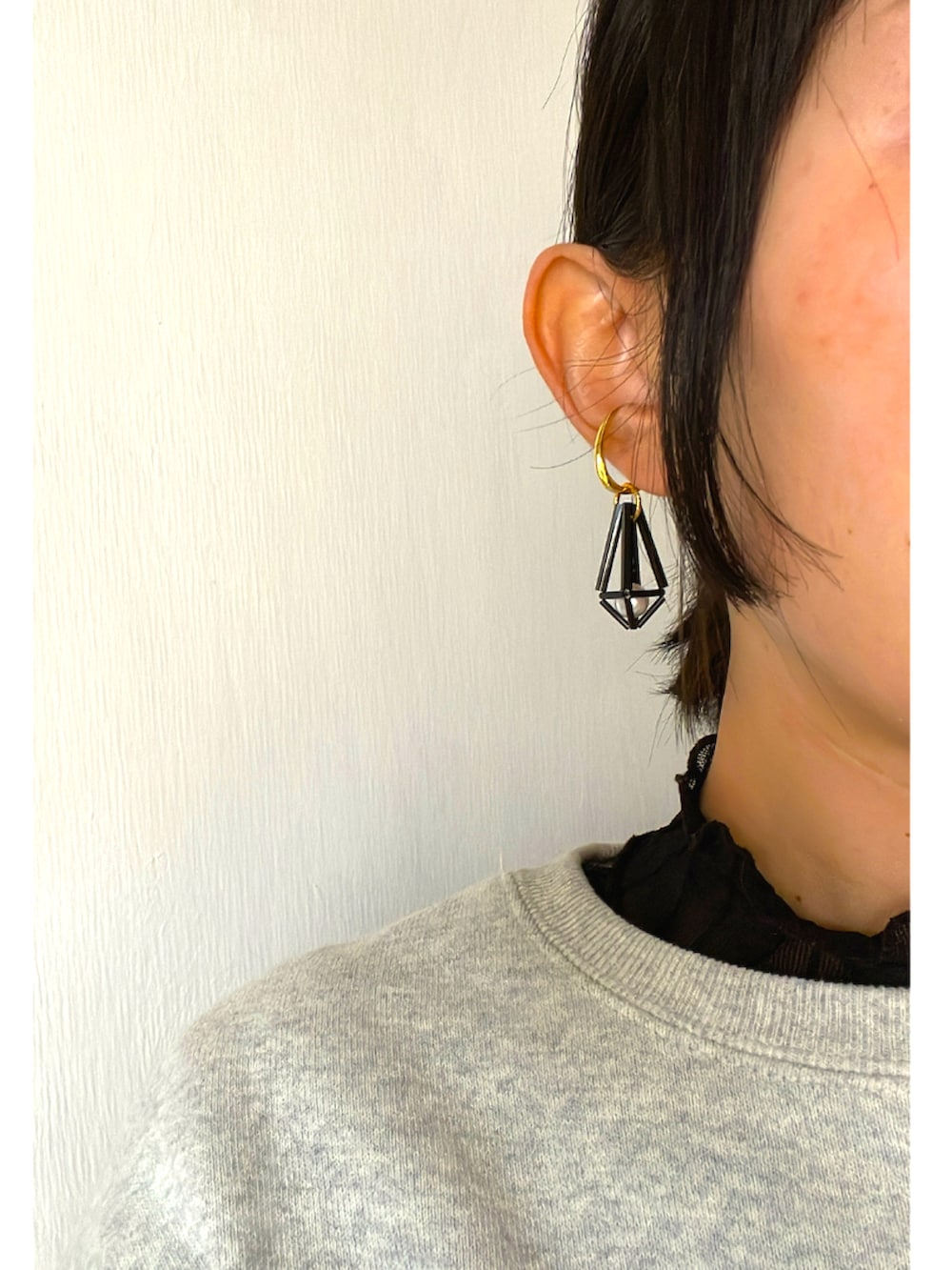 パープル系のスカート、グレー系のスウェット、ブラック系のスニーカーを着用したレディースの冬コーディネートの2枚目の写真