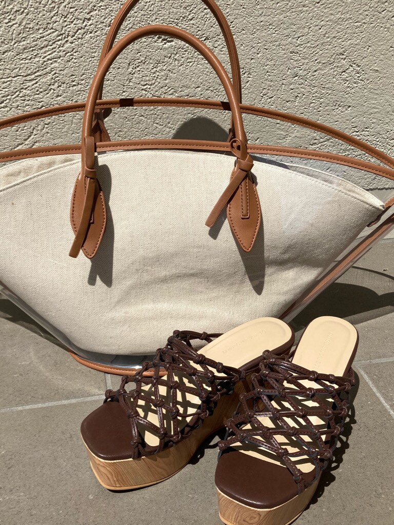 ブルー系のスカート、ブラウン系のサンダル、ベージュ系のニット/セーターを着用したレディースの春コーディネートの4枚目の写真