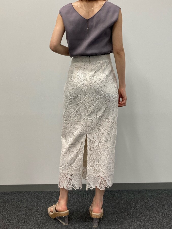 ホワイト系のスカート、ブラウン系のニット/セーター、ベージュ系のサンダルを着用したレディースの春コーディネートの4枚目の写真