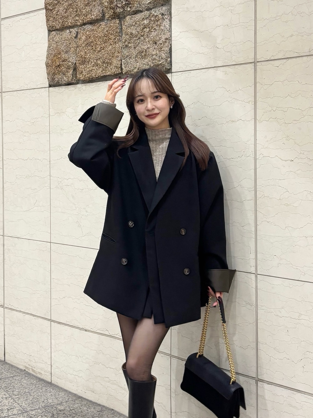 ブラック系のブーツ、ブラック系のスカート、ブラック系のショルダーバッグを着用したレディースの冬コーディネートの2枚目の写真