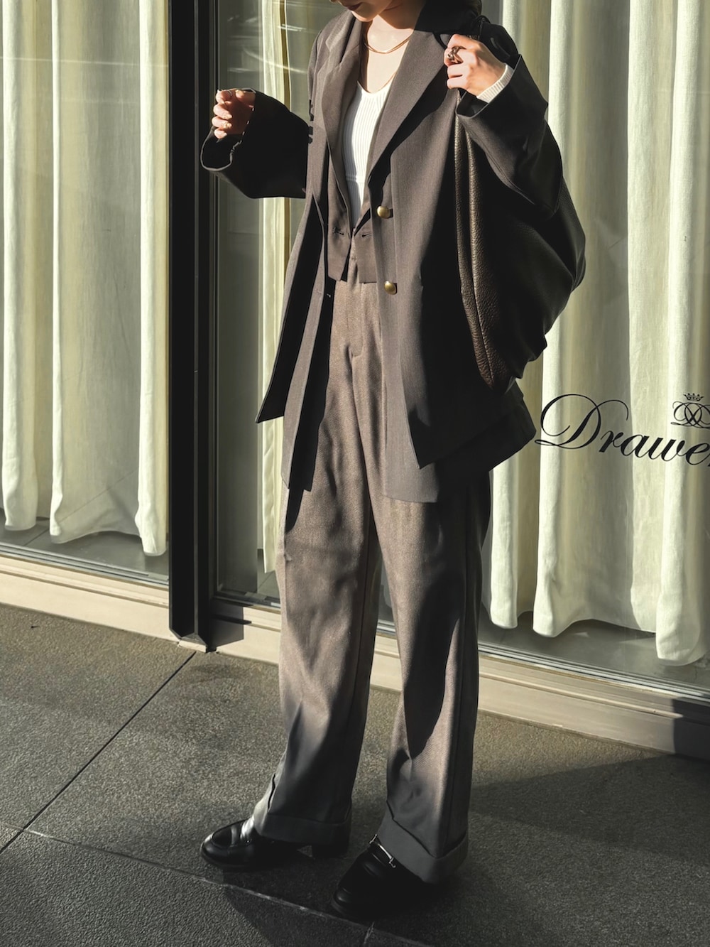 ブラック系のローファー、グレー系のテーラードジャケット、グレー系のセットアップを着用したレディースの秋コーディネートの2枚目の写真