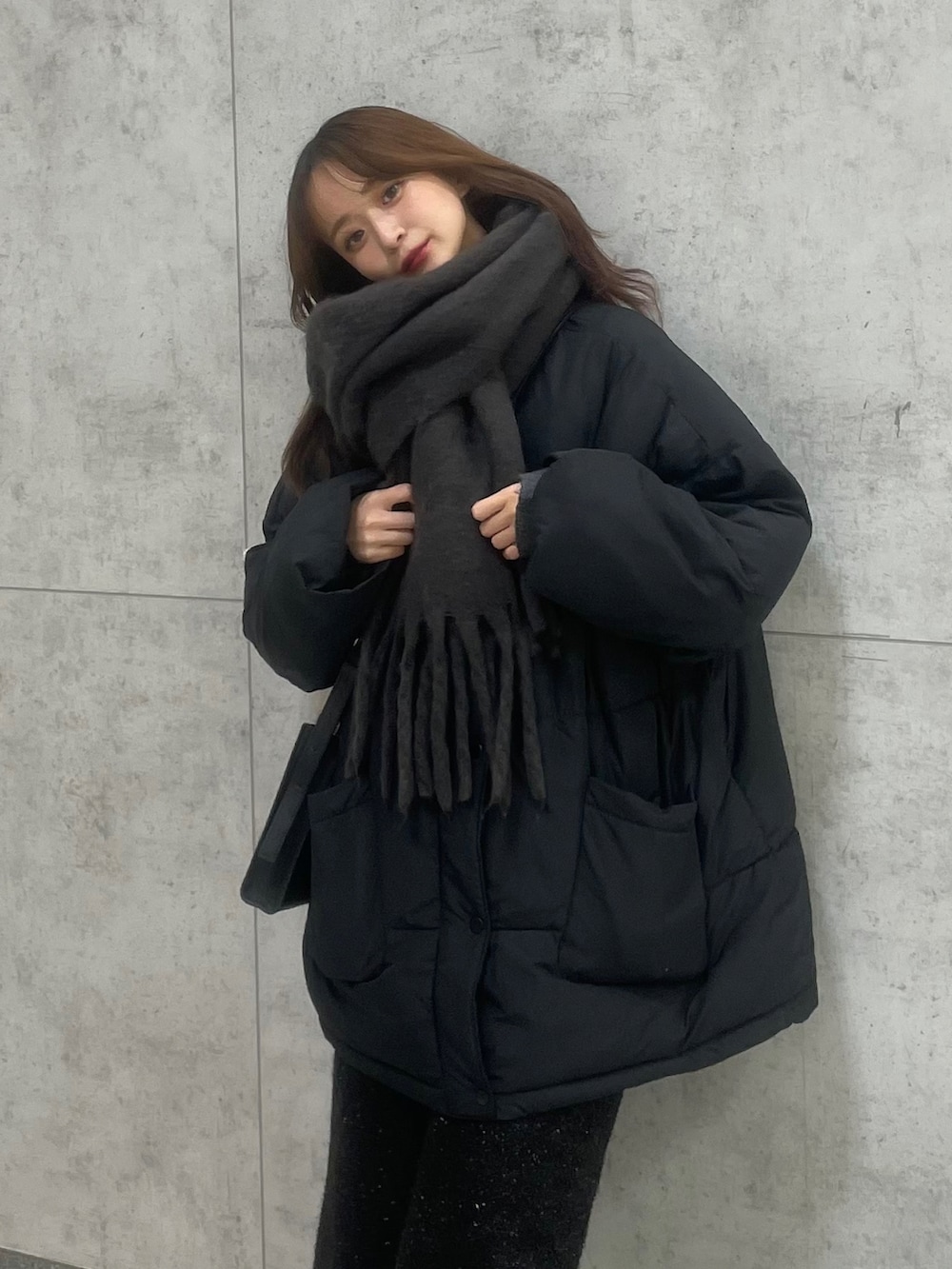 ブラック系のローファー、ブラック系のスカート、グレー系のマフラーを着用したレディースの冬コーディネートの2枚目の写真
