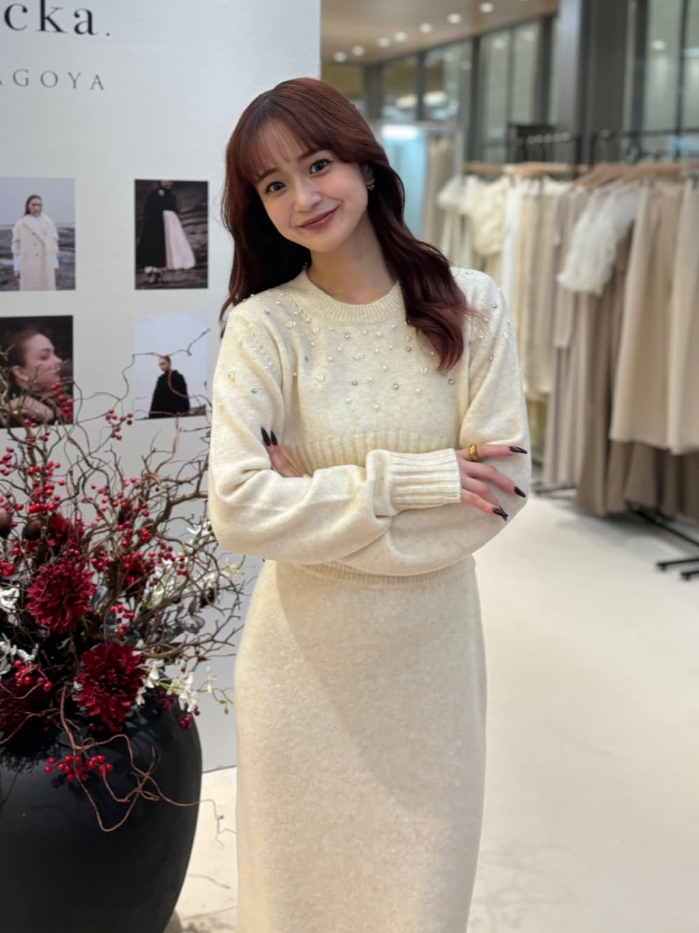 ベージュ系のワンピース、ブラック系のパンプス、ゴールド系のネックレスを着用したレディースの冬コーディネートの2枚目の写真