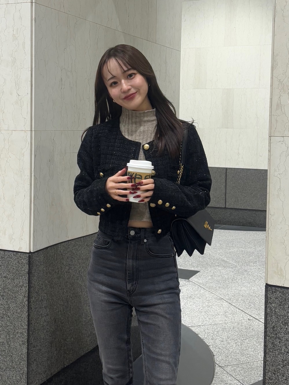 ブラック系のパンプス、ブラック系のノーカラージャケット、ブラック系のショルダーバッグを着用したレディースの冬コーディネートの2枚目の写真