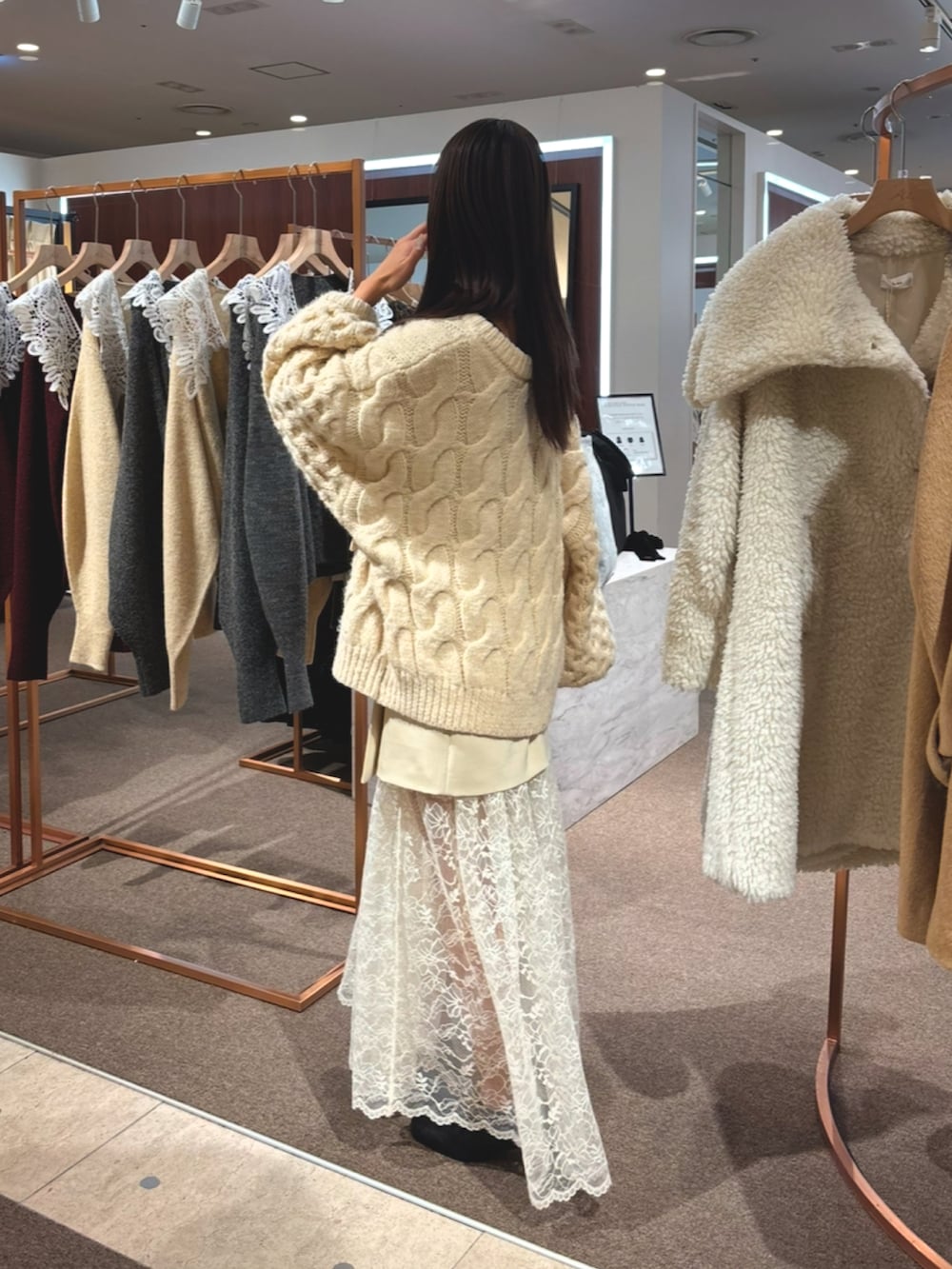 ブラック系のローファー、ベージュ系のスカート、ベージュ系のニット/セーターを着用したレディースの冬コーディネートの2枚目の写真