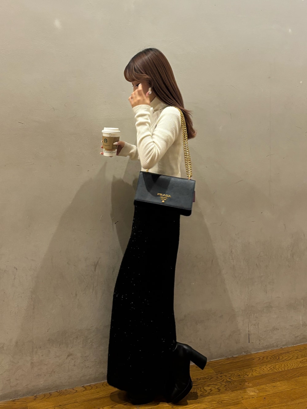 ブラック系のスカートを着用したレディースの冬コーディネートの2枚目の写真