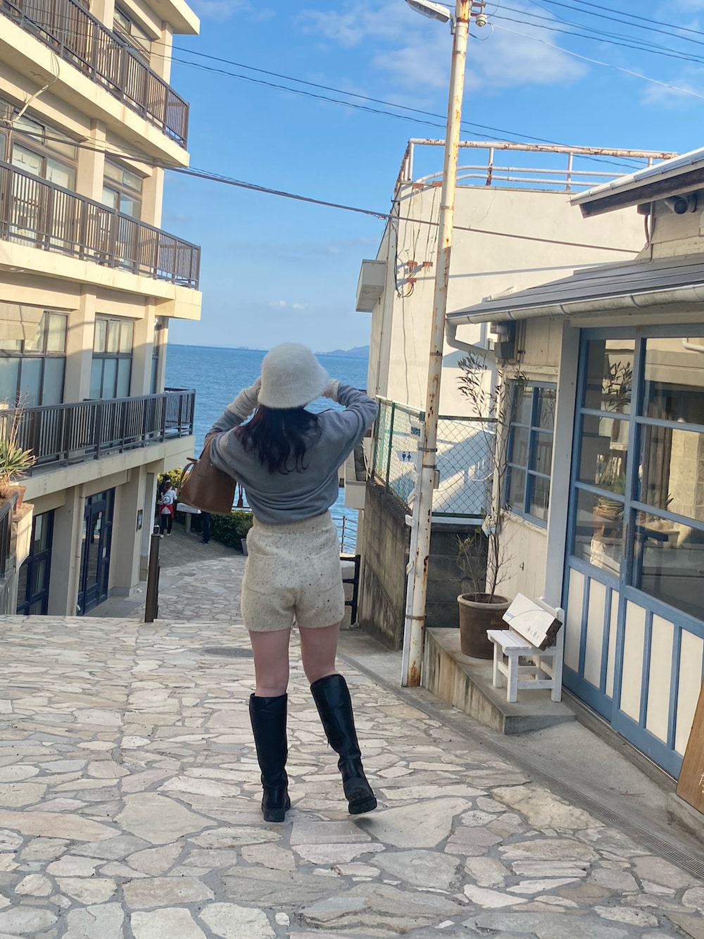 グレー系のスウェット、ホワイト系のその他パンツ、ホワイト系のアームカバーを着用したレディースの冬コーディネートの2枚目の写真