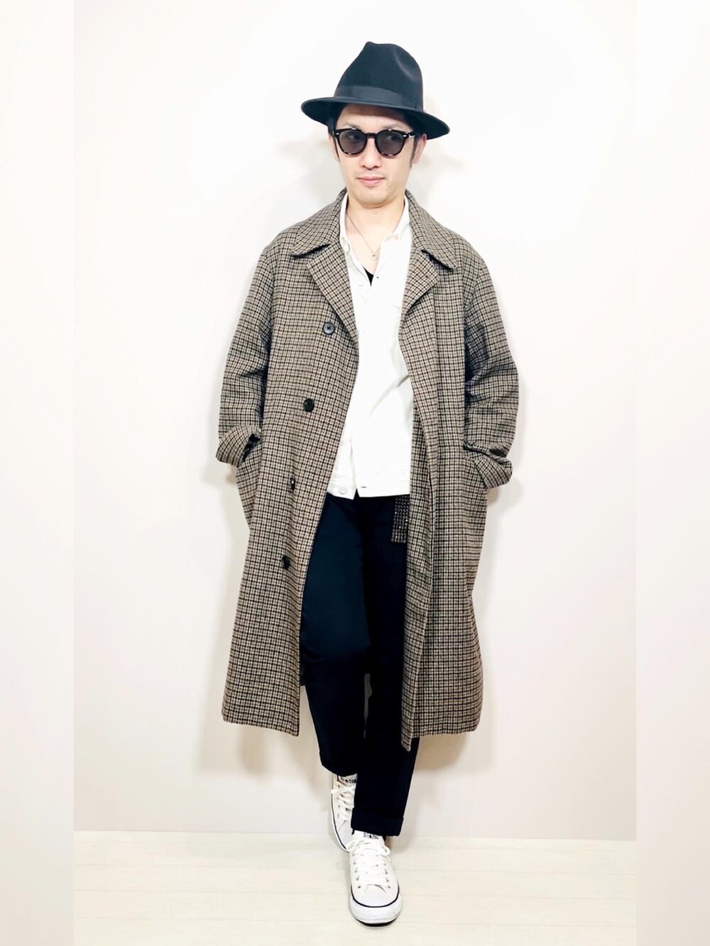 ホワイト系のブルゾン、ベージュ系のステンカラーコート、ブルー系のスラックスを着用したメンズの冬コーディネートの2枚目の写真