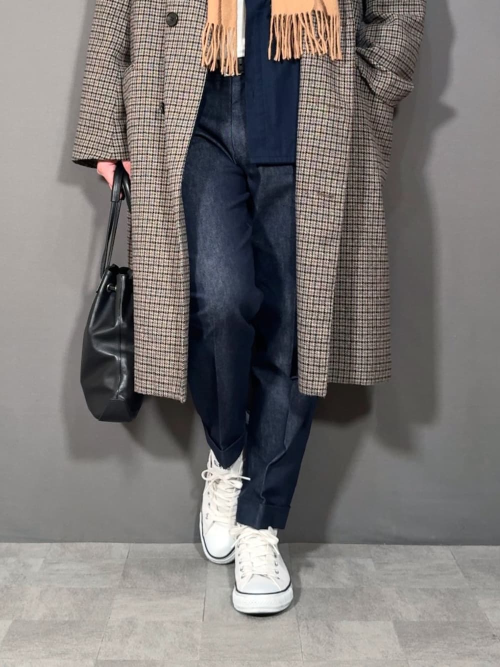 ベージュ系のステンカラーコート、ブルー系のデニムパンツ、ホワイト系のスニーカーを着用したメンズの冬コーディネートの3枚目の写真