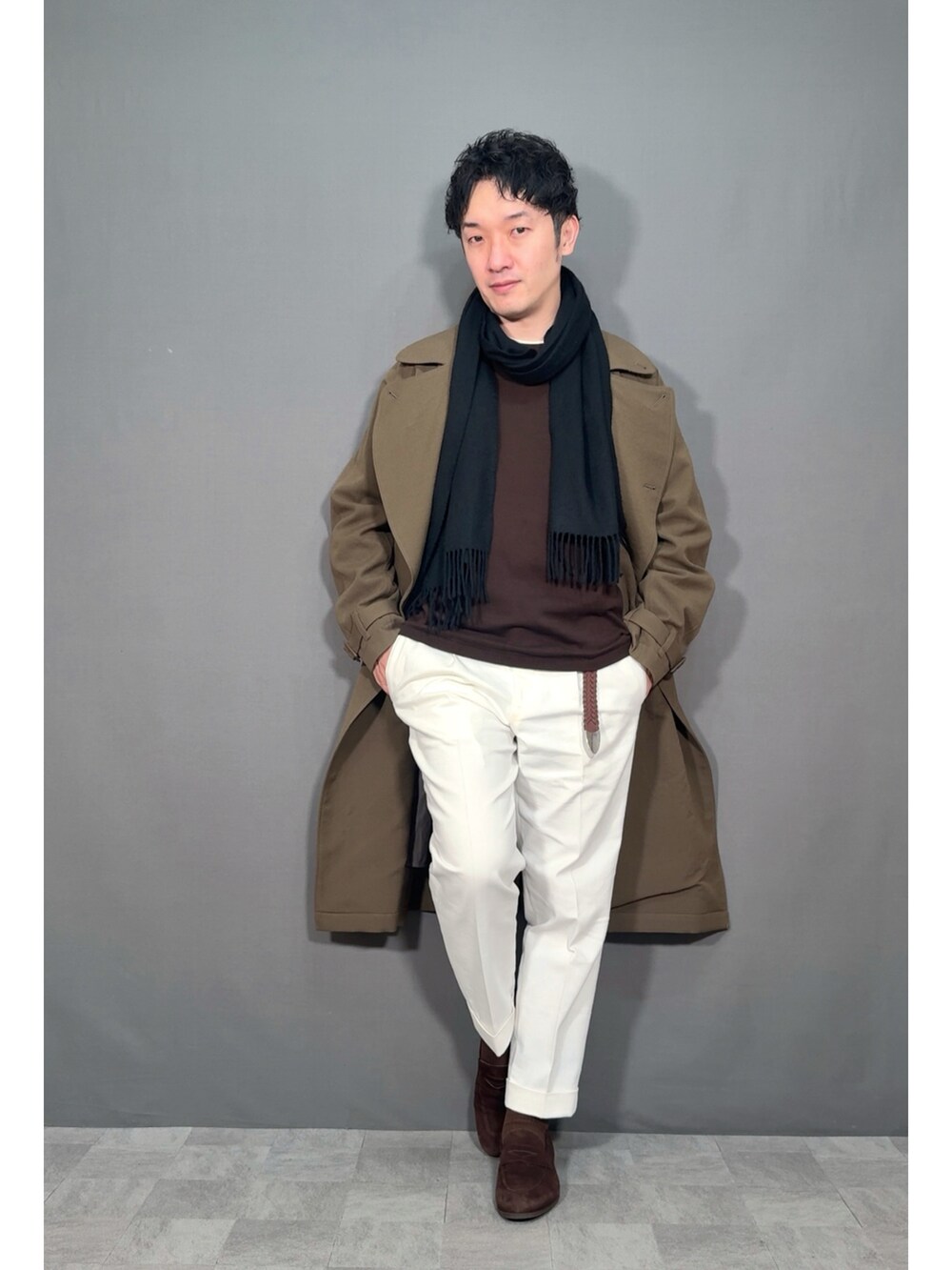 ホワイト系のスラックス、ブラウン系のローファー、グリーン系のジャケット/アウターを着用したメンズの冬コーディネートの5枚目の写真