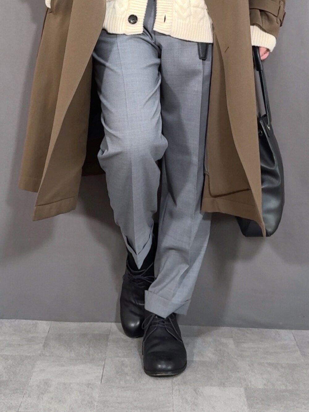 ホワイト系のカーディガン/ボレロ、グリーン系のトレンチコート、グレー系のスラックスを着用したメンズの冬コーディネートの3枚目の写真