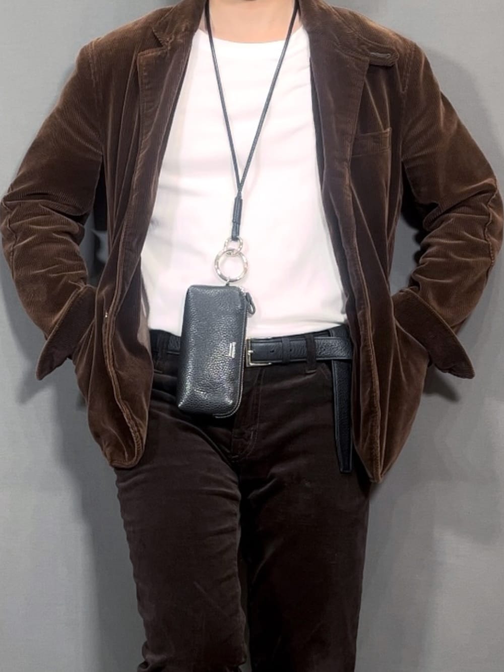 ブラウン系のテーラードジャケット、ブラウン系のパンツ、ブラック系のスニーカーを着用したメンズの秋コーディネートの2枚目の写真