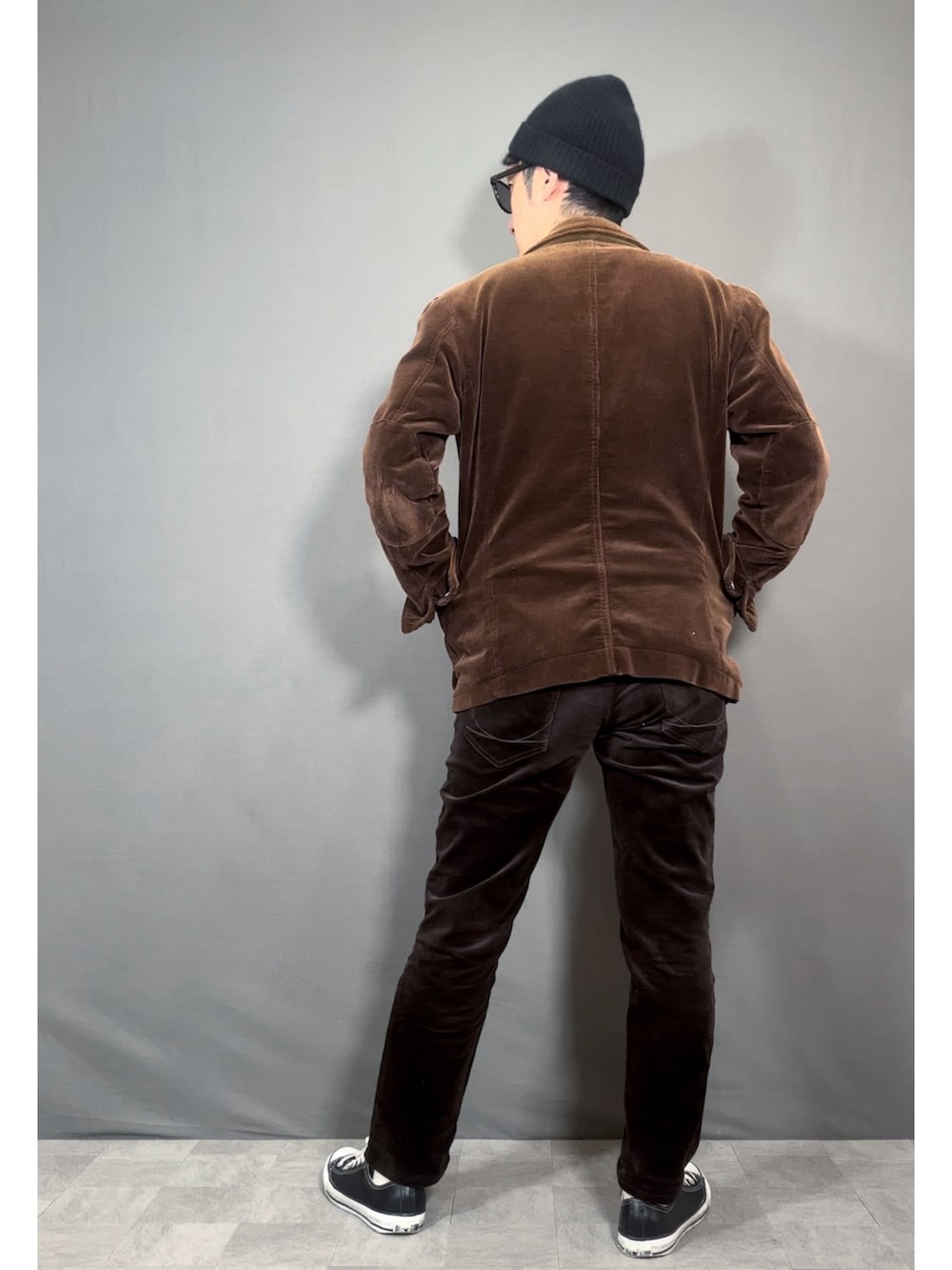 ブラウン系のテーラードジャケット、ブラウン系のパンツ、ブラック系のスニーカーを着用したメンズの秋コーディネートの4枚目の写真
