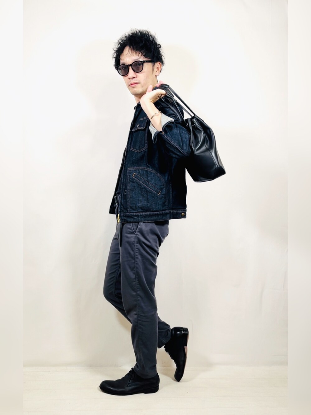 ブルー系のデニムジャケット、グレー系のパンツ、ブラック系のドレスシューズを着用したメンズの秋コーディネートの5枚目の写真