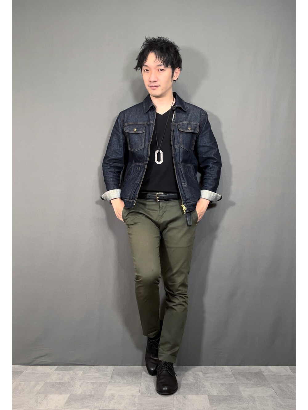 ブルー系のデニムジャケット、グリーン系のスラックス、ブラック系のドレスシューズを着用したメンズの春コーディネートの5枚目の写真