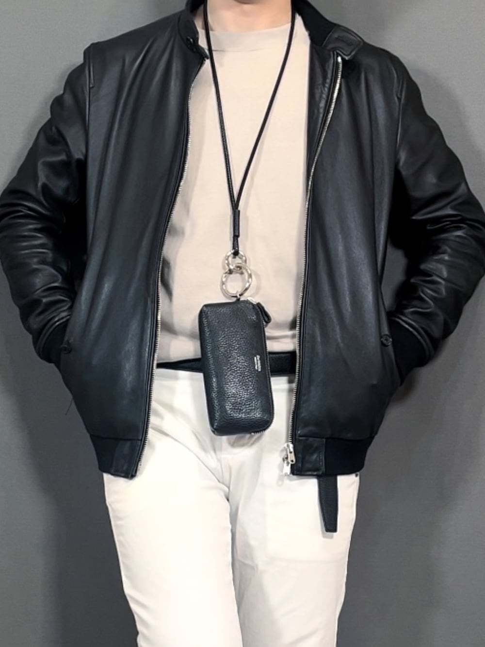 ホワイト系のスラックス、ブラック系のスニーカー、ブラック系のニットキャップ/ビーニーを着用したメンズの冬コーディネートの2枚目の写真