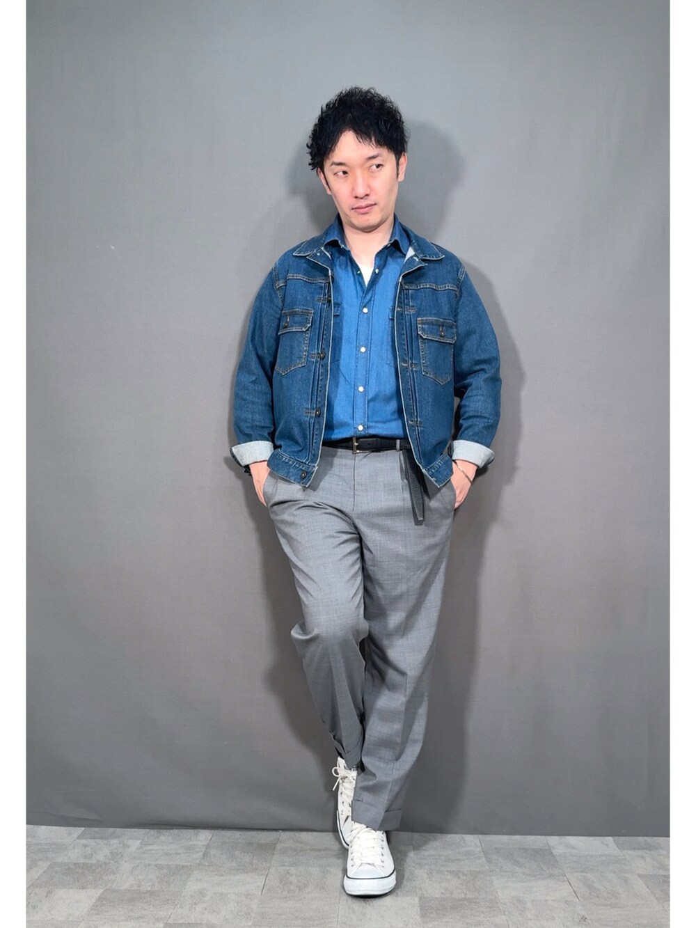 ブルー系のデニムジャケット、グレー系のスラックス、ホワイト系のスニーカーを着用したメンズの春コーディネートの5枚目の写真