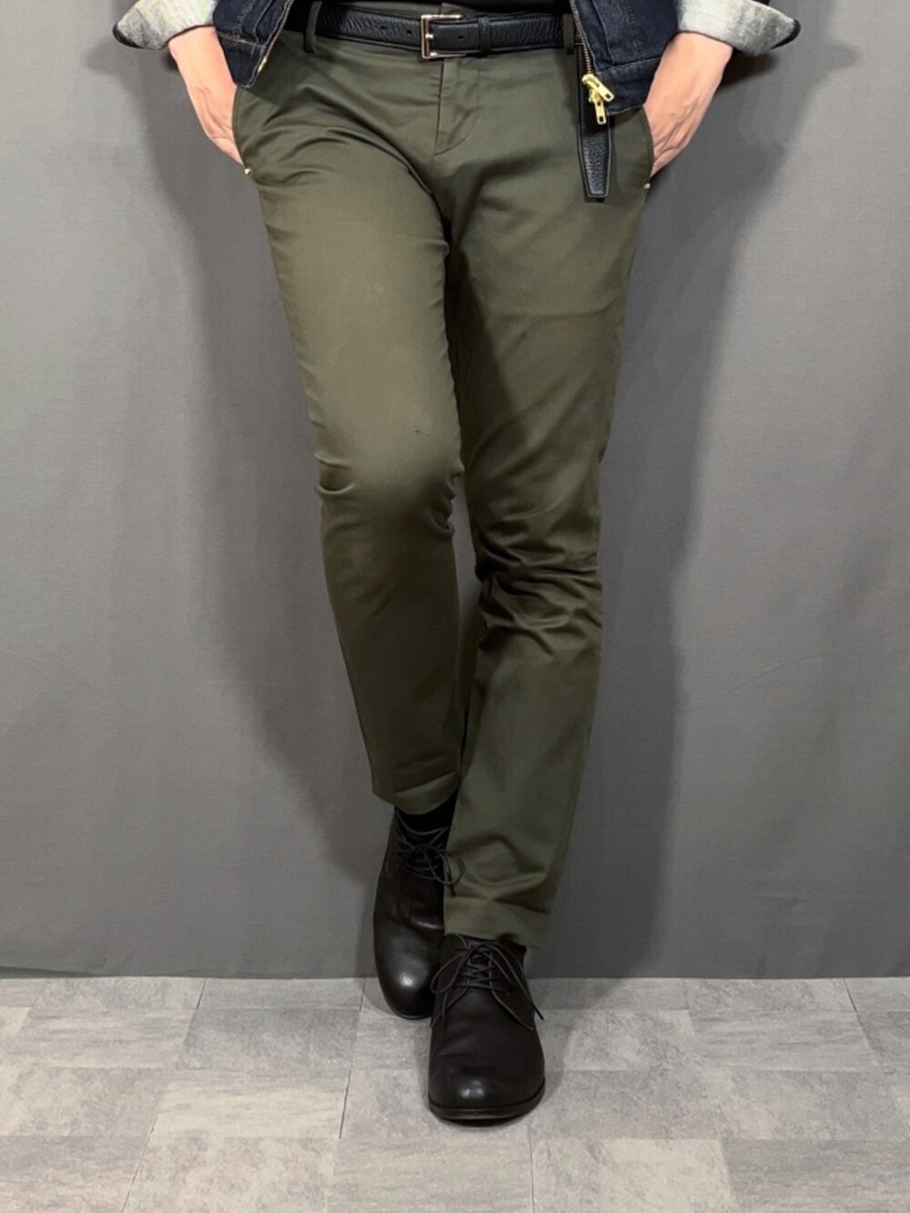 ブルー系のデニムジャケット、グリーン系のスラックス、ブラック系のドレスシューズを着用したメンズの春コーディネートの3枚目の写真