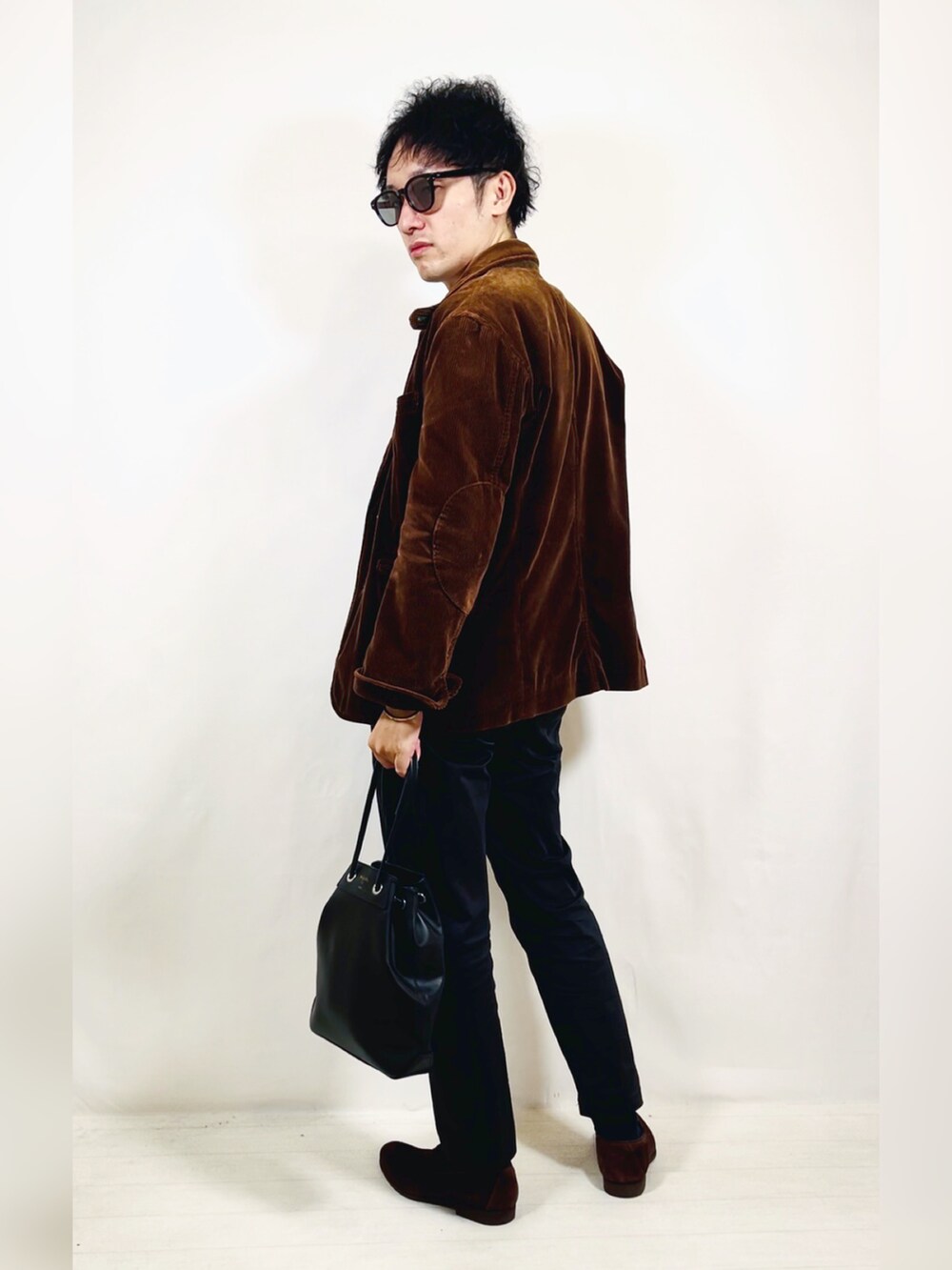 ブラウン系のテーラードジャケット、ブラック系のスラックス、ブラウン系のローファーを着用したメンズの秋コーディネートの4枚目の写真