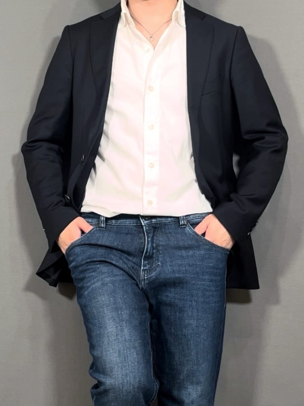 ブラック系のテーラードジャケット、ホワイト系のシャツ/ブラウス、ブルー系のデニムパンツを着用したメンズの春コーディネートの2枚目の写真