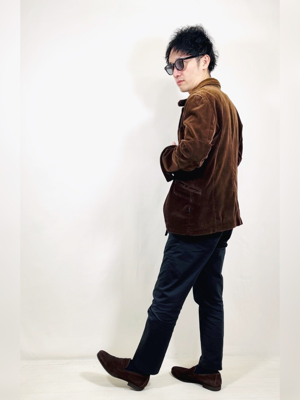 ブラウン系のテーラードジャケット、ブラック系のスラックス、ブラウン系のローファーを着用したメンズの秋コーディネートの3枚目の写真