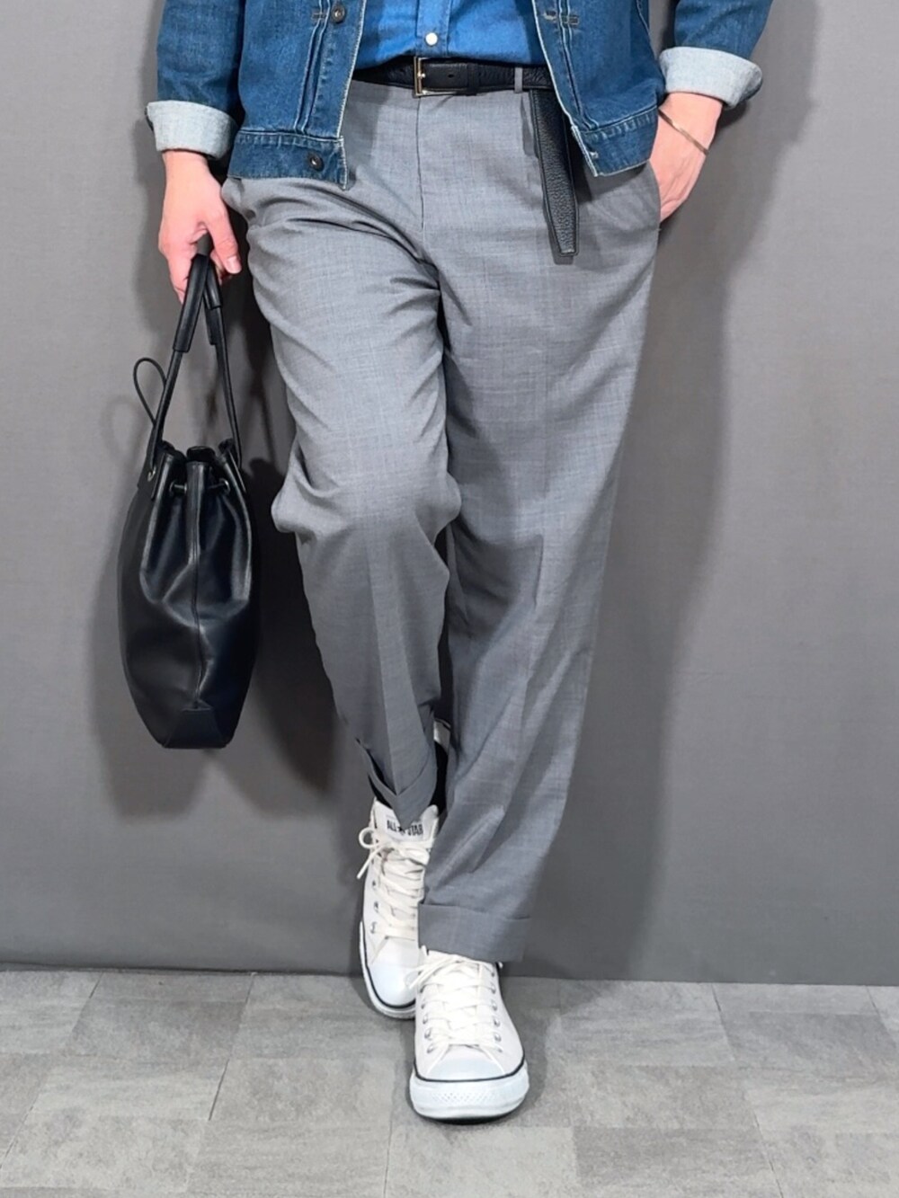 ブルー系のデニムジャケット、グレー系のスラックス、ホワイト系のスニーカーを着用したメンズの春コーディネートの3枚目の写真