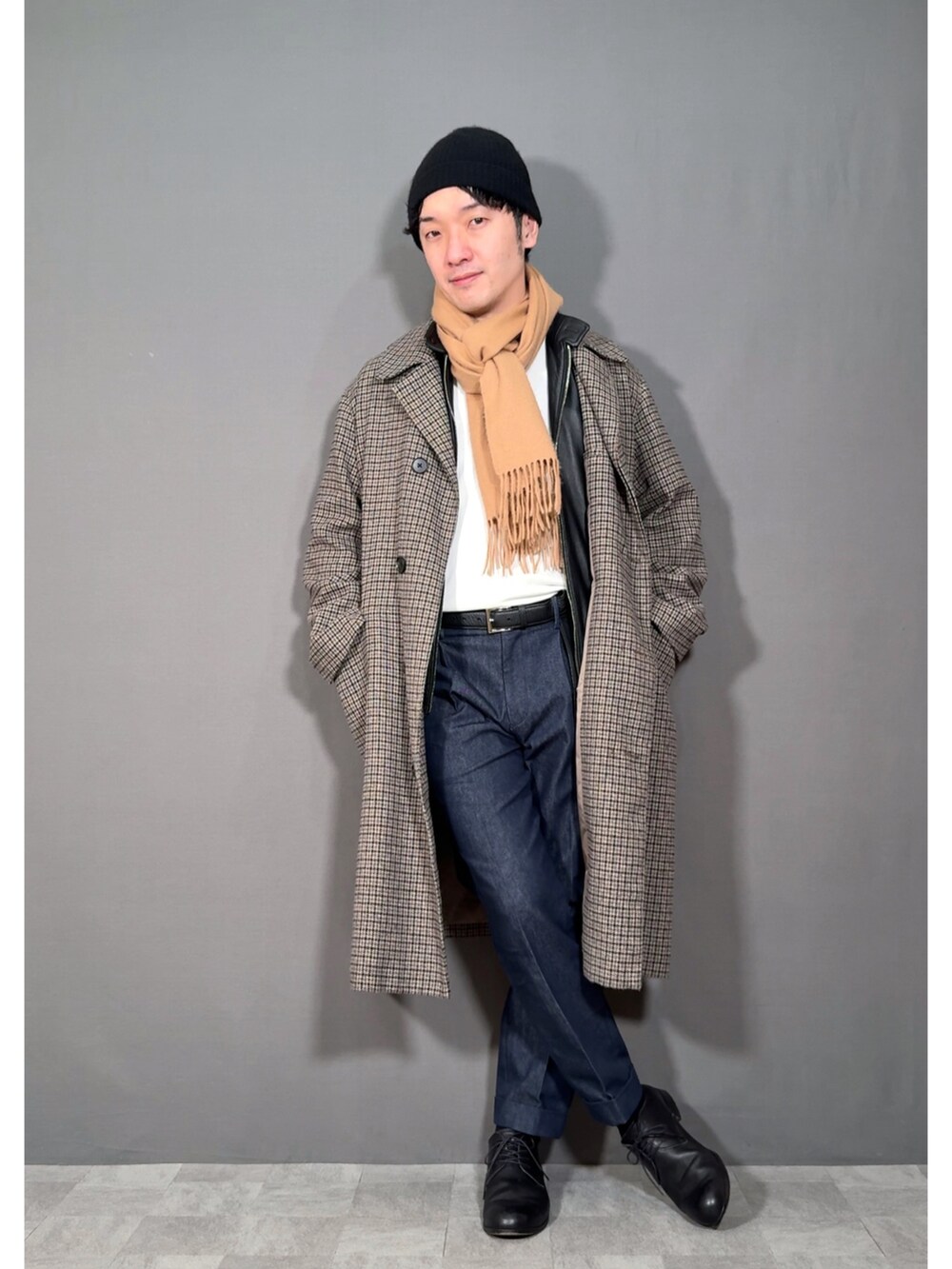 ベージュ系のステンカラーコート、ブルー系のスラックス、ブラック系のドレスシューズを着用したメンズの冬コーディネートの5枚目の写真