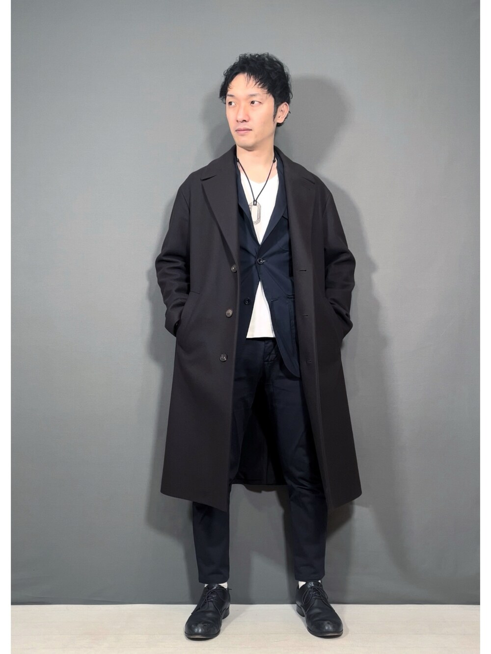 ブラウン系のジャケット/アウター、ブルー系のスラックス、ブラック系のドレスシューズを着用したメンズの冬コーディネートの5枚目の写真