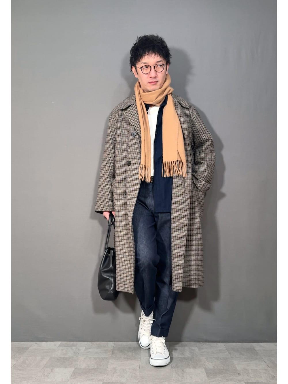 ベージュ系のステンカラーコート、ブルー系のデニムパンツ、ホワイト系のスニーカーを着用したメンズの冬コーディネートの5枚目の写真