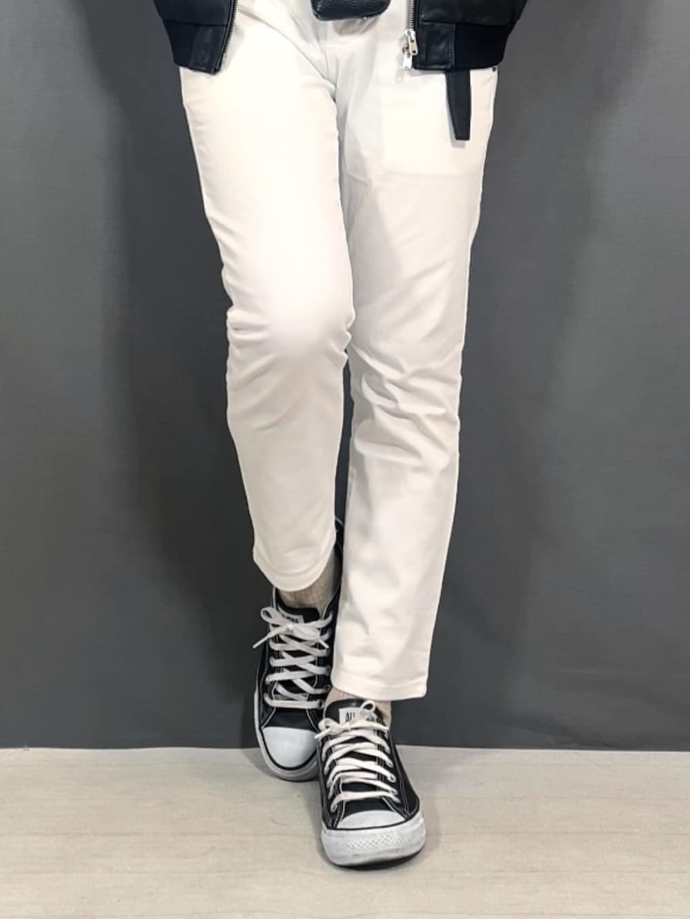 ホワイト系のスラックス、ブラック系のスニーカー、ブラック系のニットキャップ/ビーニーを着用したメンズの冬コーディネートの3枚目の写真