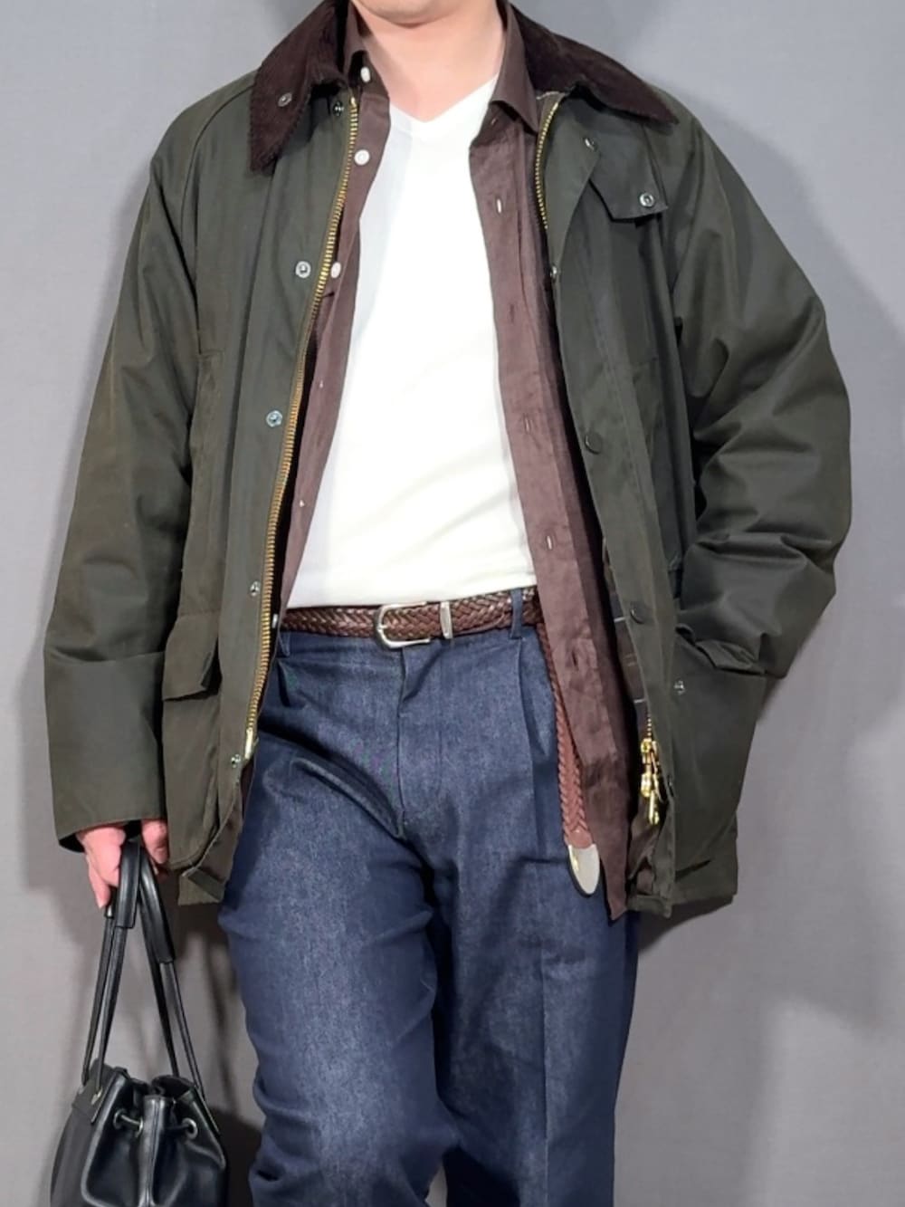 グリーン系のジャケット/アウター、ブルー系のデニムパンツ、ホワイト系のスニーカーを着用したメンズの春コーディネートの2枚目の写真