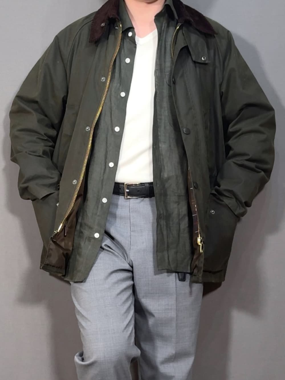 グリーン系のジャケット/アウター、グレー系のスラックス、ブラック系のドレスシューズを着用したメンズの春コーディネートの2枚目の写真