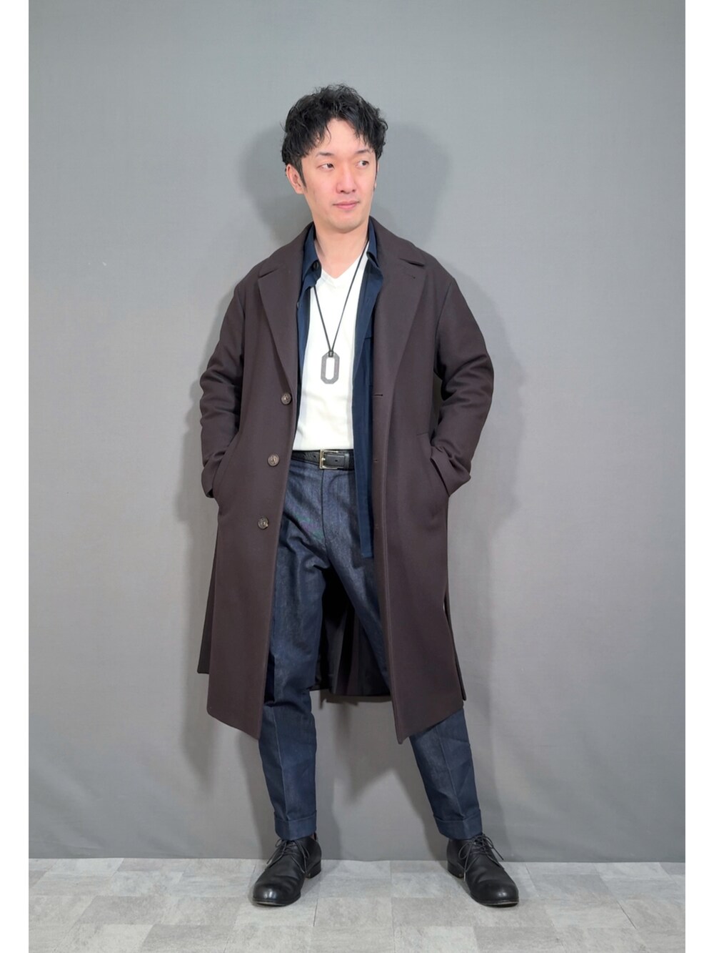 ブラウン系のジャケット/アウター、ブルー系のスラックス、ブラック系のドレスシューズを着用したメンズの冬コーディネートの5枚目の写真