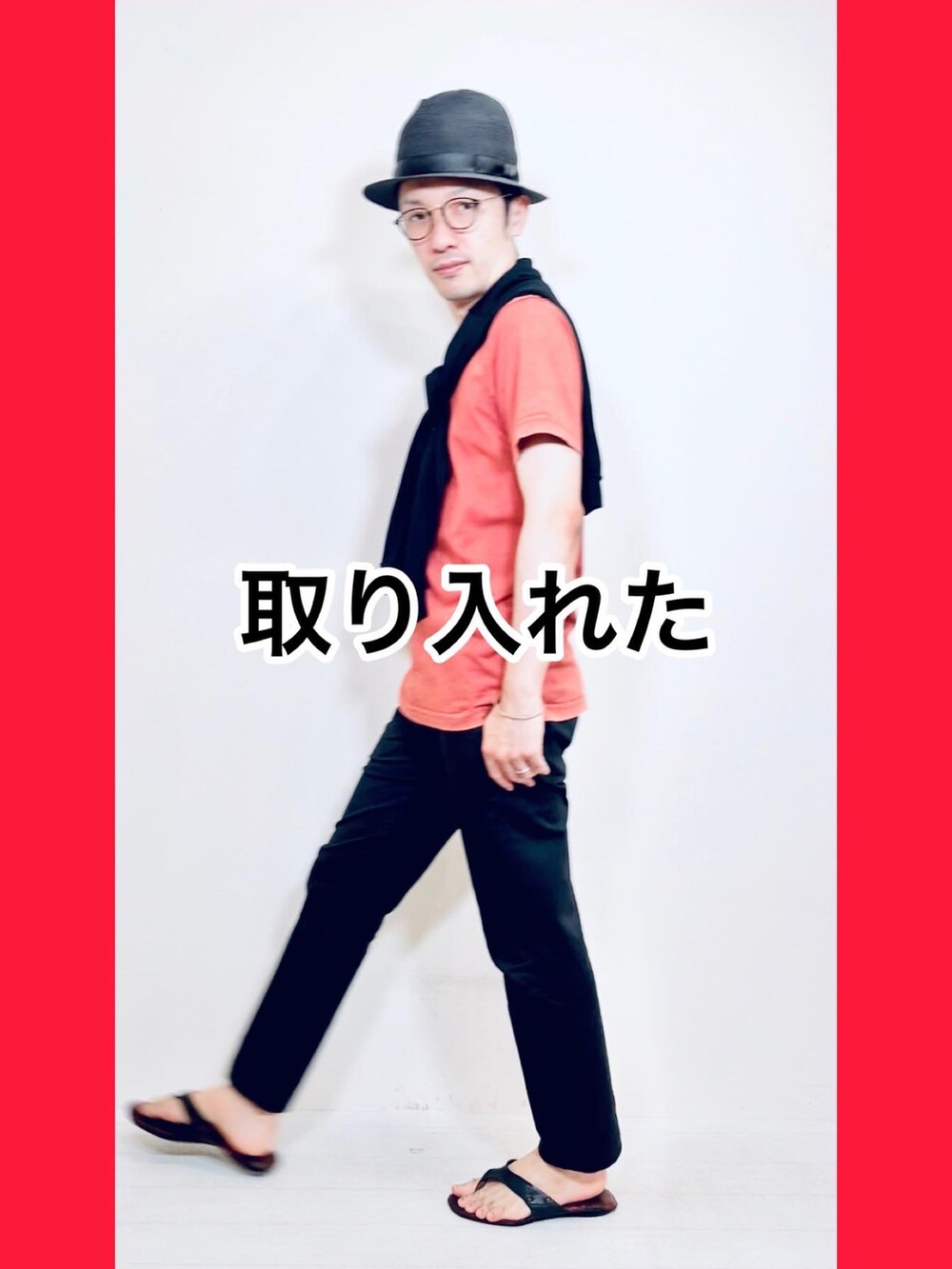ブラック系のスラックス、レッド系のTシャツ/カットソー、ブラック系のハットを着用したメンズの夏コーディネートの3枚目の写真