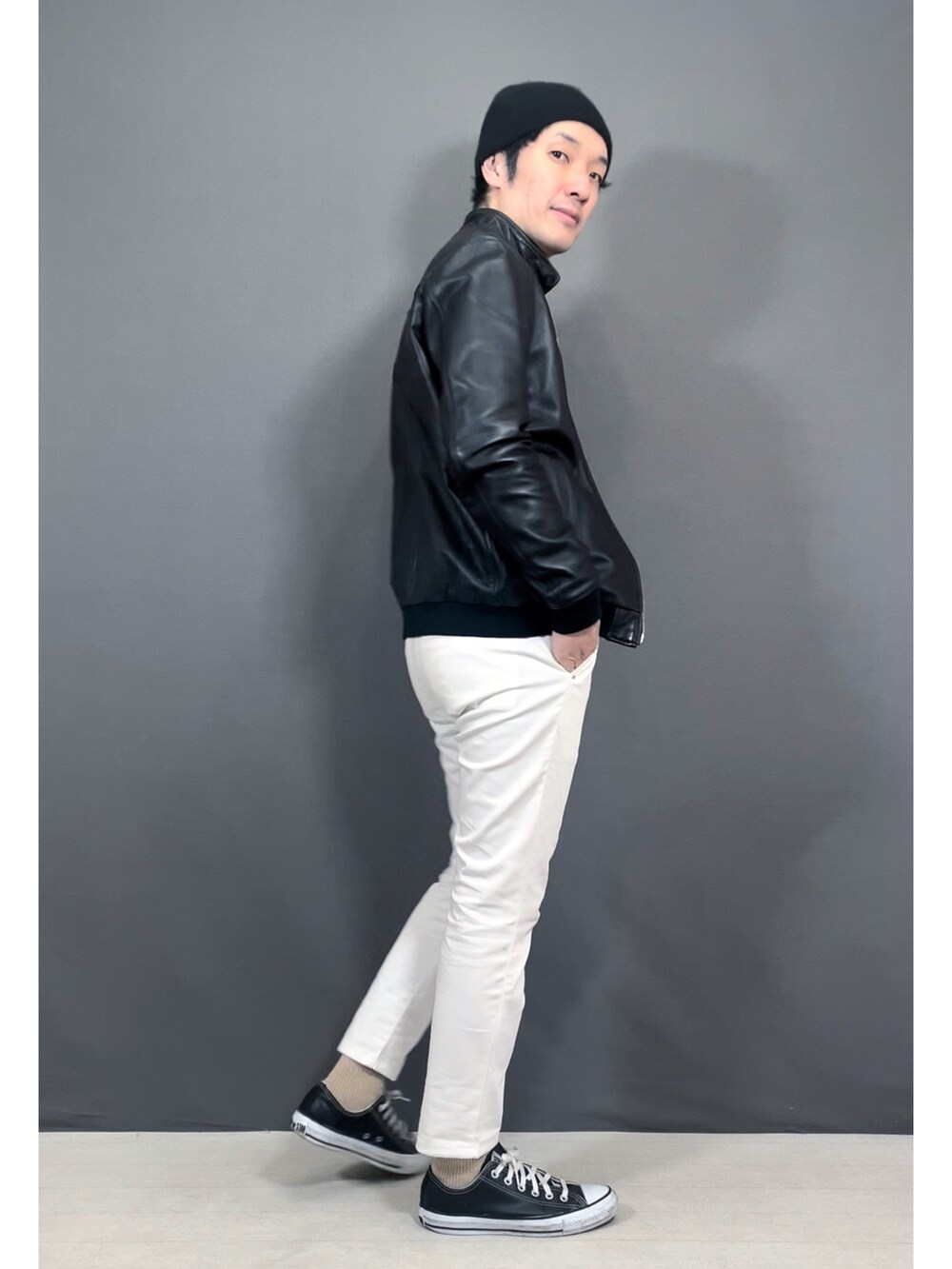 ホワイト系のスラックス、ブラック系のスニーカー、ブラック系のニットキャップ/ビーニーを着用したメンズの冬コーディネートの5枚目の写真