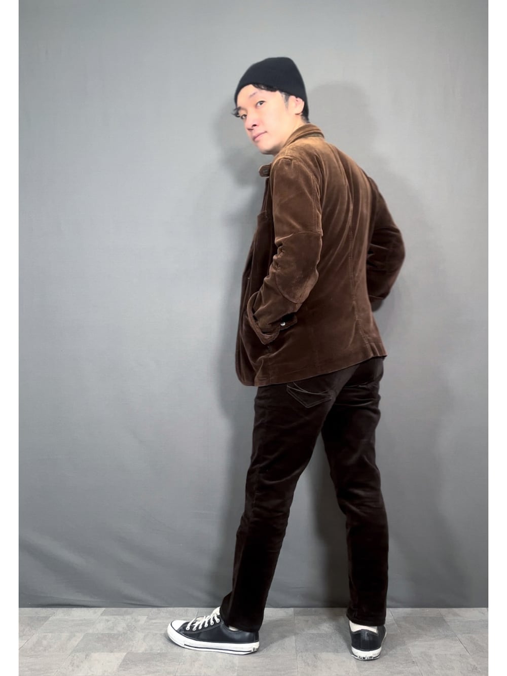 ブラウン系のテーラードジャケット、ブラウン系のパンツ、ブラック系のスニーカーを着用したメンズの秋コーディネートの5枚目の写真