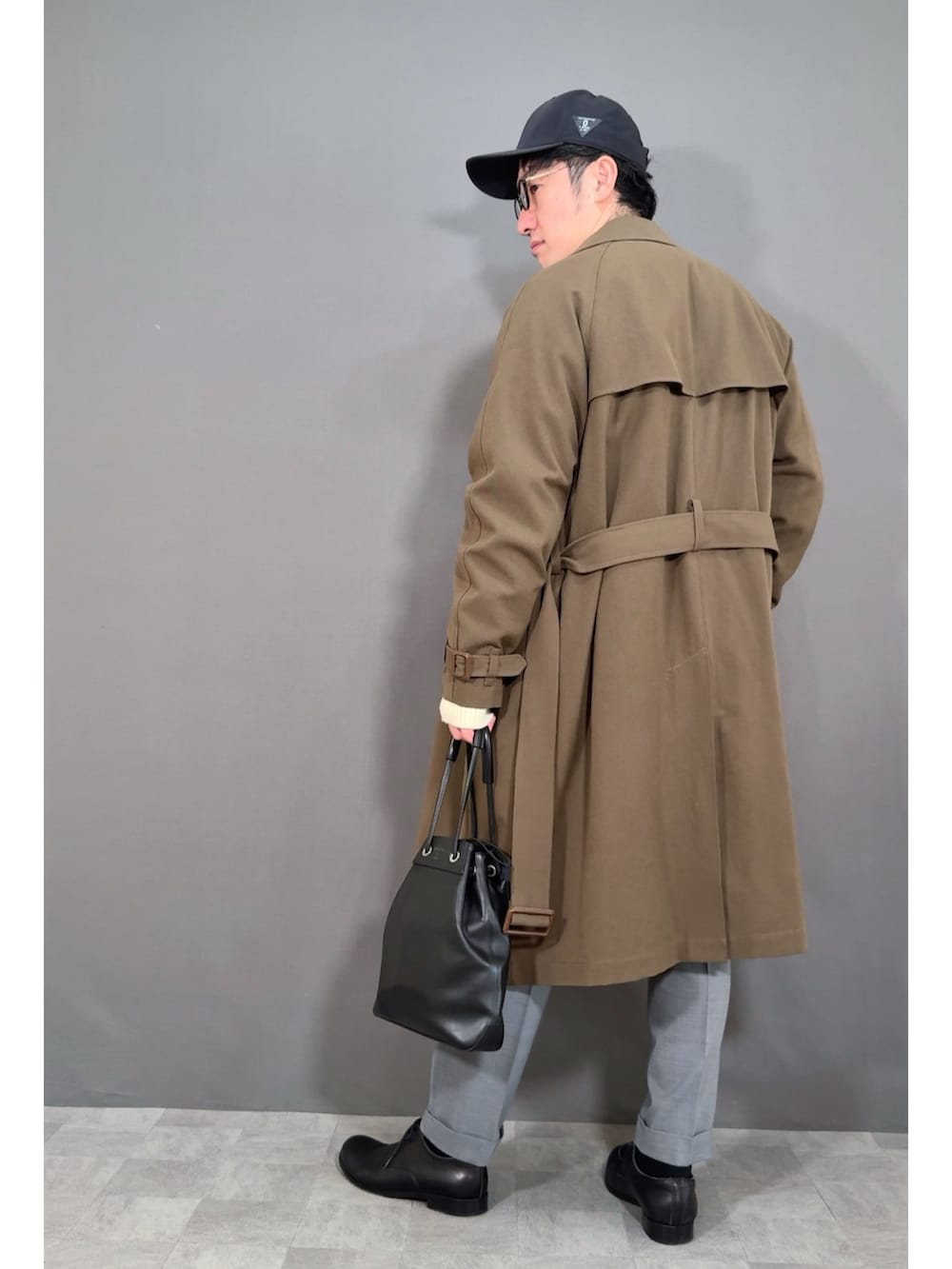 ホワイト系のカーディガン/ボレロ、グリーン系のトレンチコート、グレー系のスラックスを着用したメンズの冬コーディネートの4枚目の写真