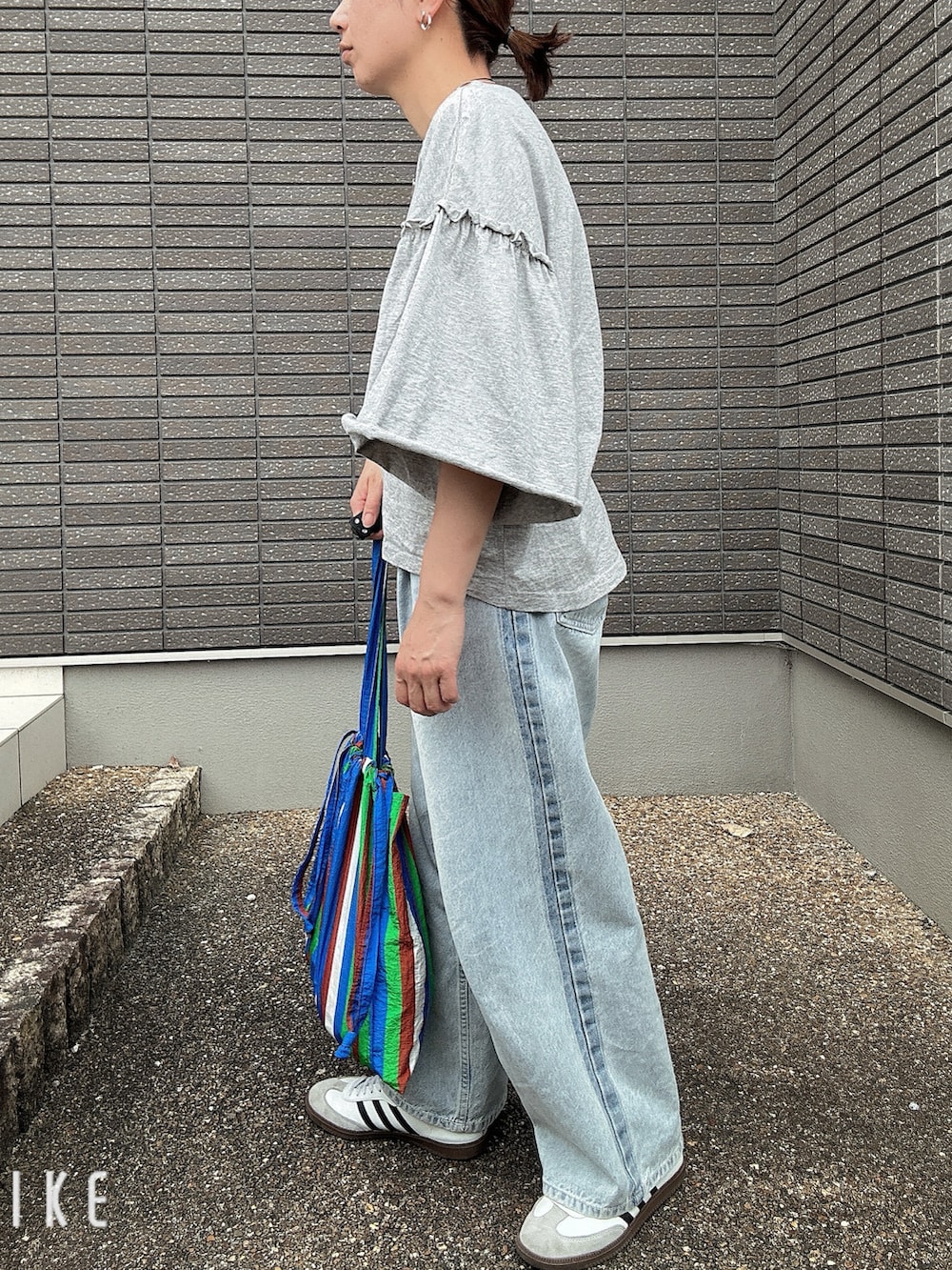 グレー系のTシャツ/カットソー、ブルー系のデニムパンツ、ブルー系のトートバッグを着用したレディースの夏コーディネートの2枚目の写真