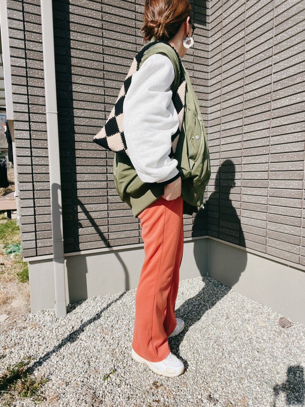 グリーン系のMA-1、ブラック系のTシャツ/カットソー、オレンジ系のその他パンツを着用したレディースの冬コーディネートの3枚目の写真