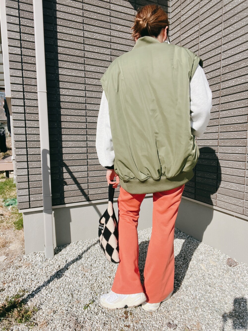 グリーン系のMA-1、ブラック系のTシャツ/カットソー、オレンジ系のその他パンツを着用したレディースの冬コーディネートの4枚目の写真