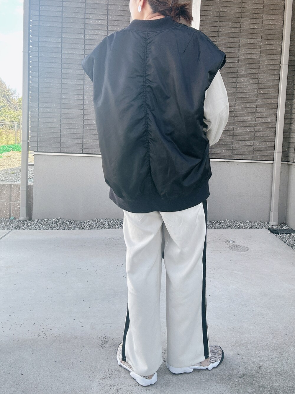 ブラック系のダウンベスト、グリーン系のスウェット、ブラック系のトートバッグを着用したレディースの秋コーディネートの3枚目の写真