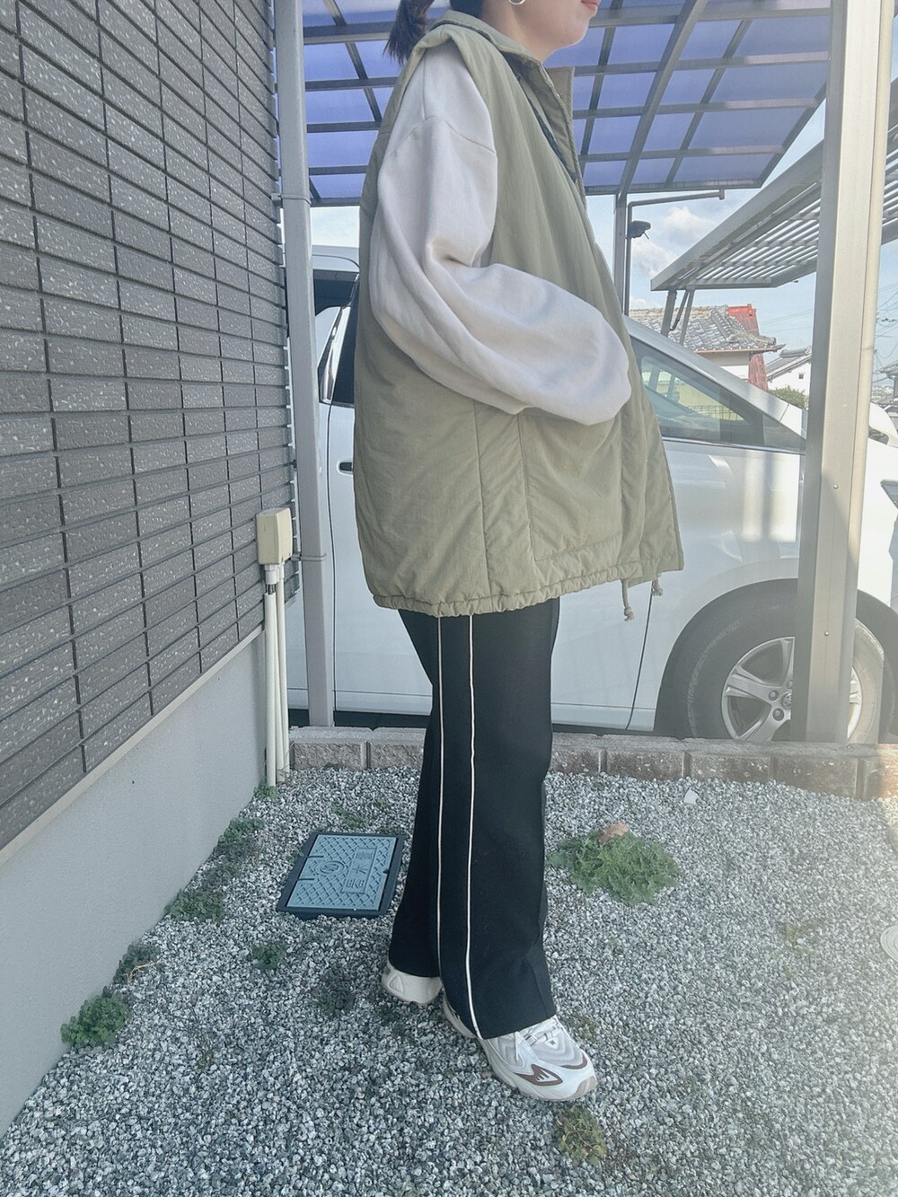 ホワイト系のスウェット、ブラック系のショルダーバッグ、ホワイト系のスニーカーを着用したレディースの冬コーディネートの2枚目の写真