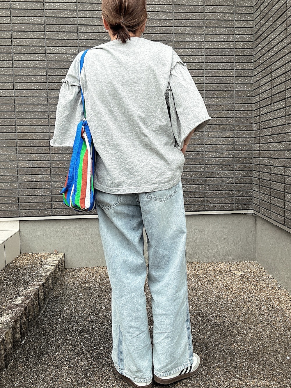 グレー系のTシャツ/カットソー、ブルー系のデニムパンツ、ブルー系のトートバッグを着用したレディースの夏コーディネートの3枚目の写真