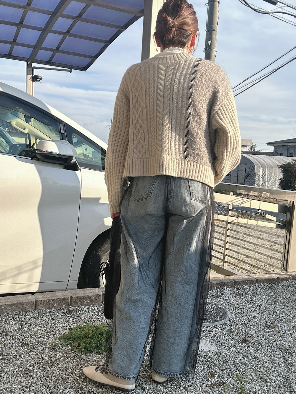 ホワイト系のカーディガン/ボレロ、ブラック系のその他パンツ、ブルー系のデニムパンツを着用したレディースの冬コーディネートの2枚目の写真