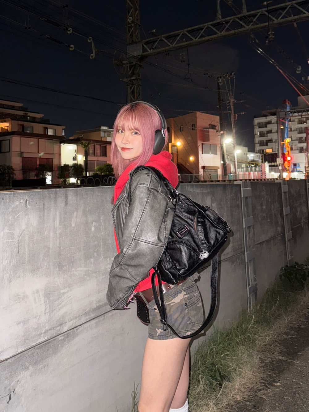 レッド系のパーカー、グレー系のライダースジャケット、ブラック系のバッグを着用したレディースの冬コーディネートの3枚目の写真