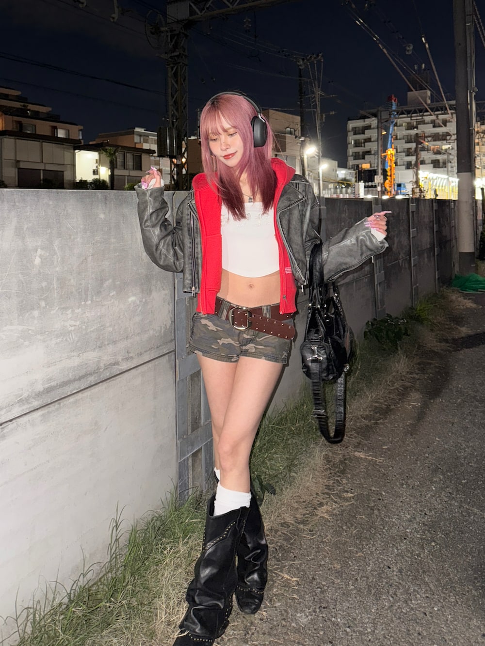 レッド系のパーカー、グレー系のライダースジャケット、ブラック系のバッグを着用したレディースの冬コーディネートの2枚目の写真