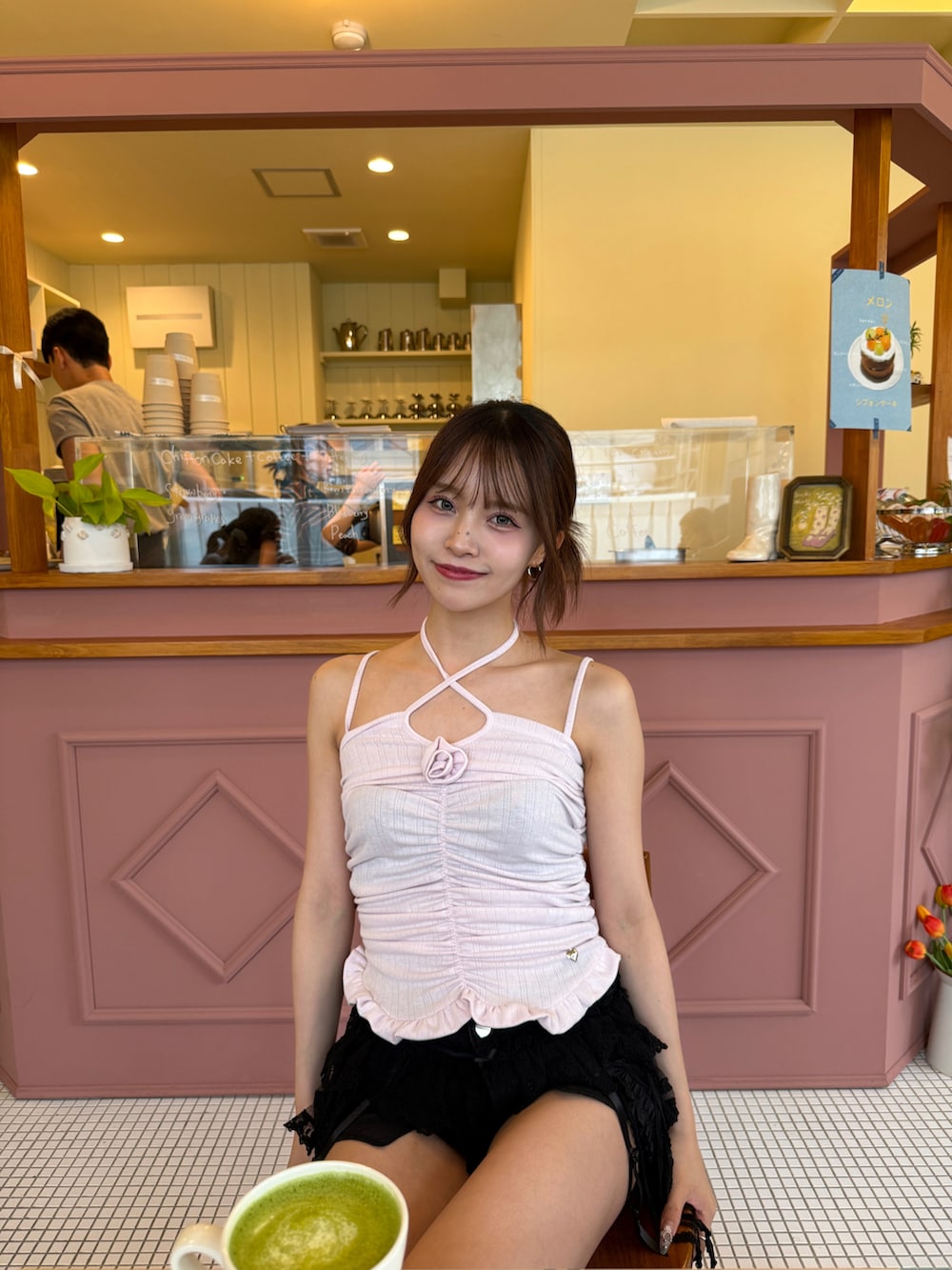 ピンク系のトップス、ブラック系のデニムパンツ、ブラック系のブーツを着用したレディースの夏コーディネートの2枚目の写真