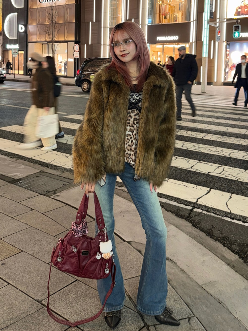 ブラウン系のステンカラーコート、ブラック系のTシャツ/カットソー、グレー系のブーツを着用したレディースの冬コーディネートの2枚目の写真